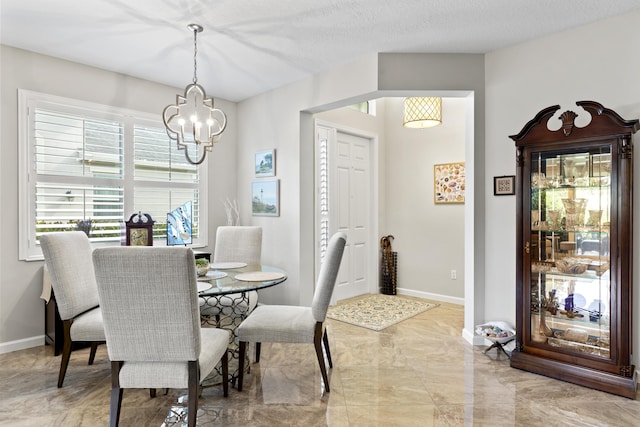 dining room with a textured ceiling and a notable chandelier