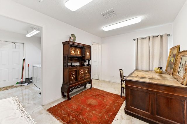 office with washer and clothes dryer and a textured ceiling