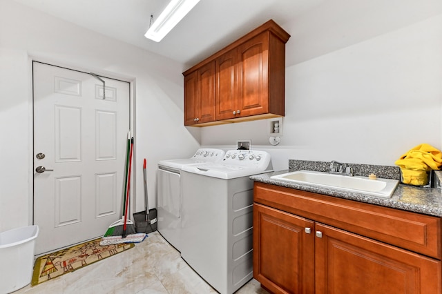 clothes washing area featuring washer and dryer, cabinets, and sink