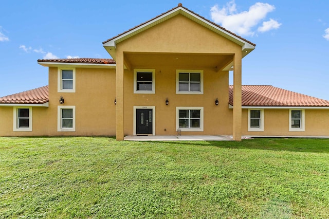 back of property featuring a patio area and a yard