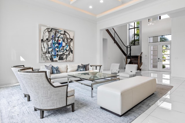 living room with a towering ceiling, ornamental molding, and french doors