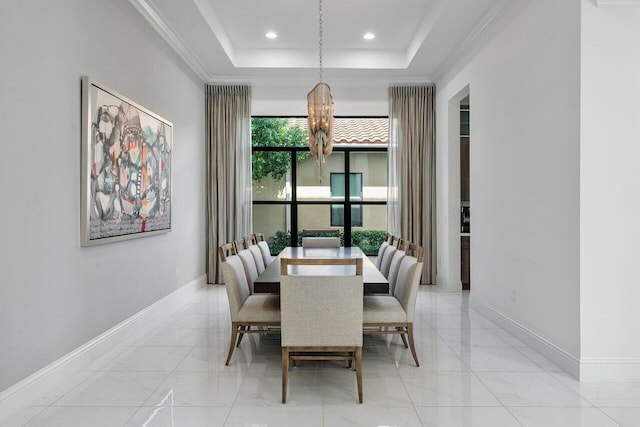 dining room with a tray ceiling, a notable chandelier, and ornamental molding