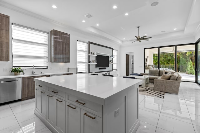 kitchen featuring stainless steel dishwasher, gray cabinetry, ceiling fan, sink, and a kitchen island