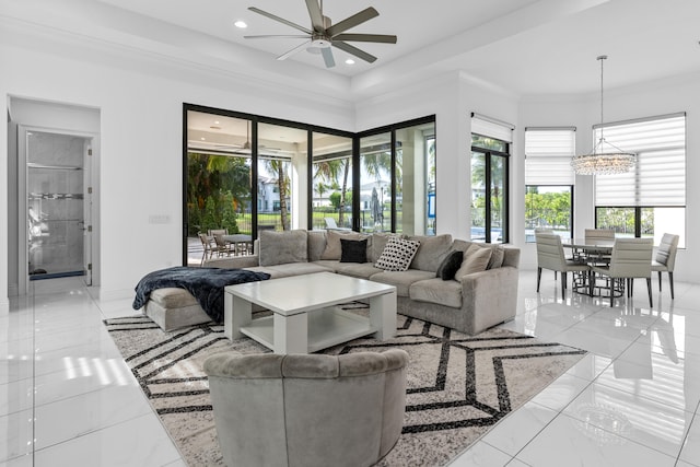 living room with ceiling fan with notable chandelier and ornamental molding