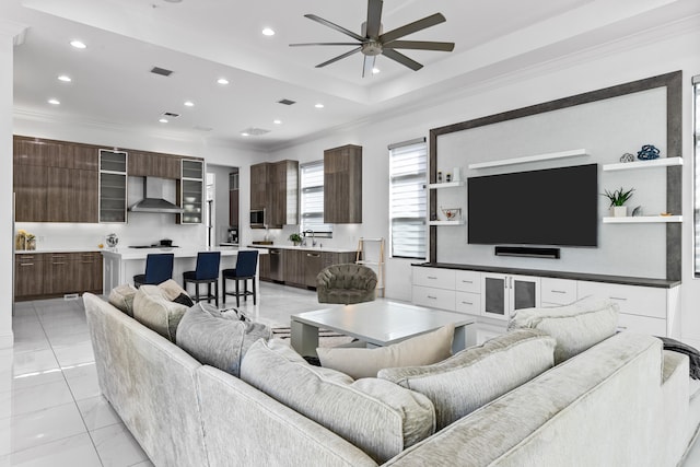 living room with ceiling fan, crown molding, light tile patterned floors, and sink