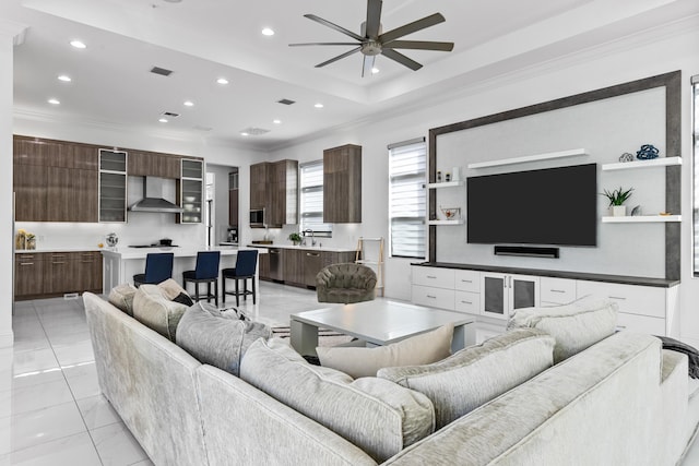 living room featuring sink, crown molding, and ceiling fan