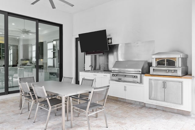 view of patio with grilling area, ceiling fan, and an outdoor kitchen