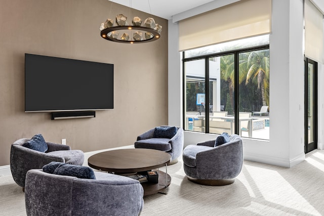 living room with light colored carpet and an inviting chandelier