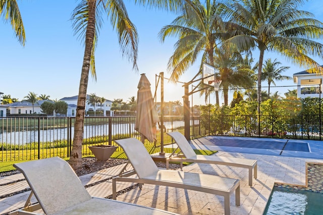 view of patio / terrace with a water view and basketball hoop