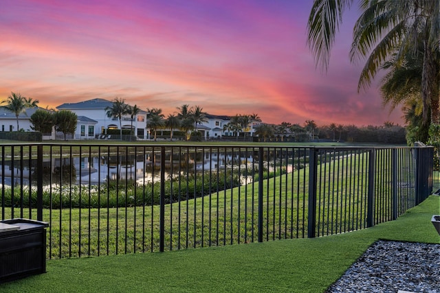 yard at dusk featuring a water view