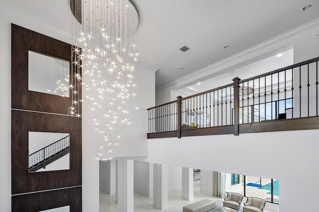 stairway featuring ornamental molding and a notable chandelier