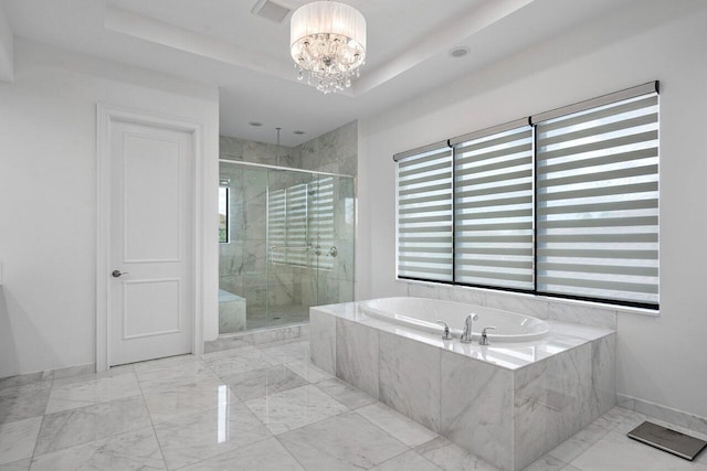 bathroom with a raised ceiling, independent shower and bath, and a chandelier