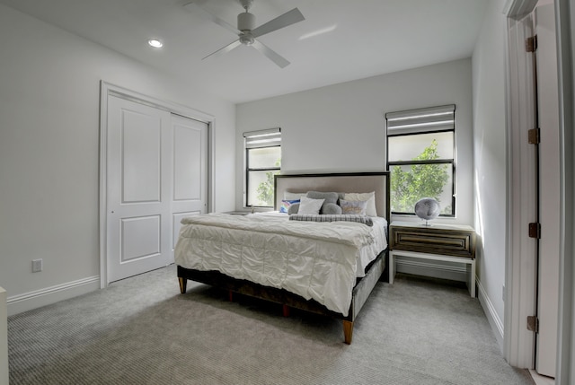 carpeted bedroom featuring ceiling fan and a closet