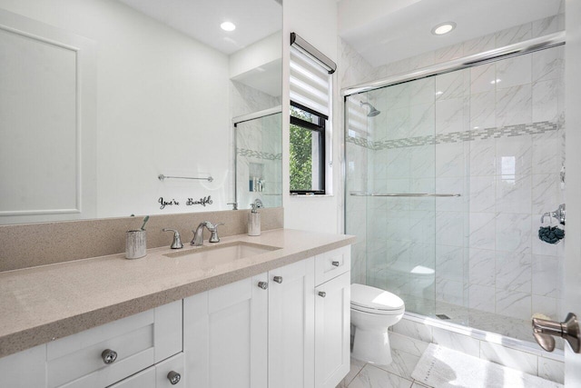 bathroom featuring vanity, toilet, and a shower with door