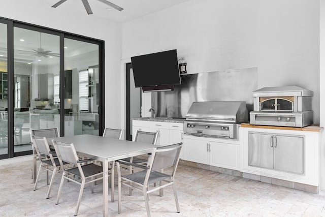 view of patio with ceiling fan, area for grilling, and sink