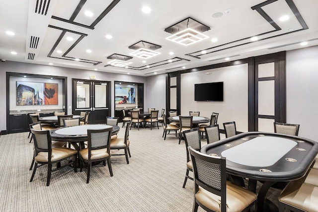 carpeted dining room with french doors and a raised ceiling