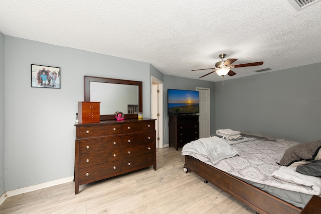 bedroom with ceiling fan, a textured ceiling, and light hardwood / wood-style flooring