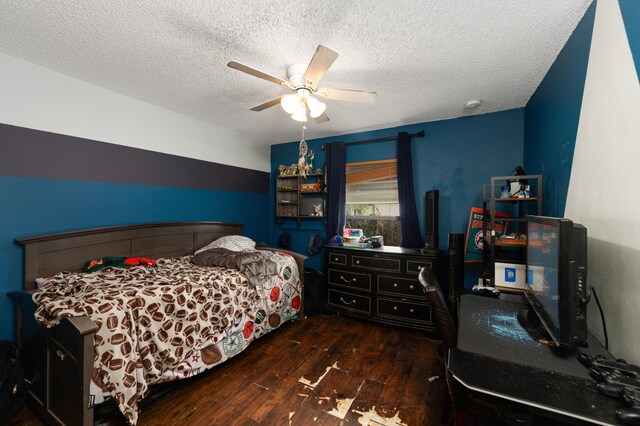 bedroom with dark hardwood / wood-style floors, ceiling fan, and a textured ceiling