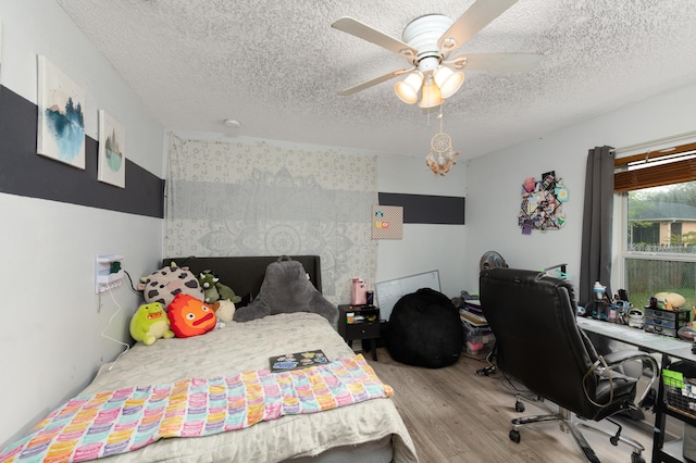 bedroom with ceiling fan, a textured ceiling, and light wood-type flooring