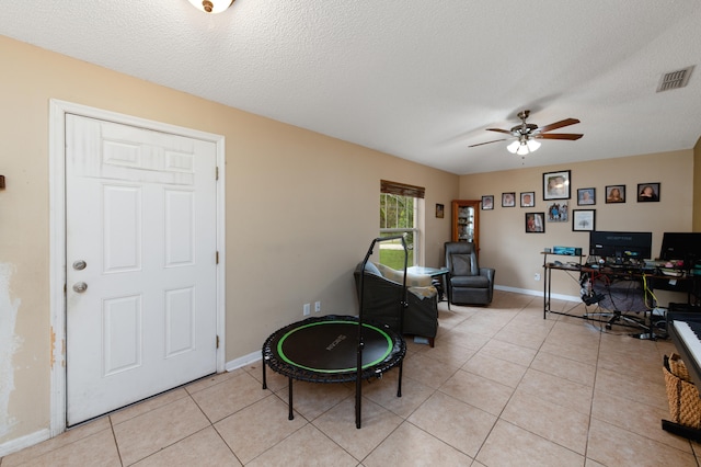 tiled office featuring ceiling fan and a textured ceiling