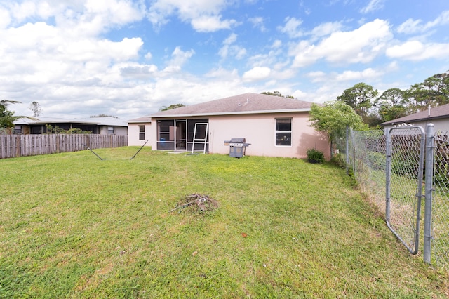 back of property featuring a sunroom and a yard