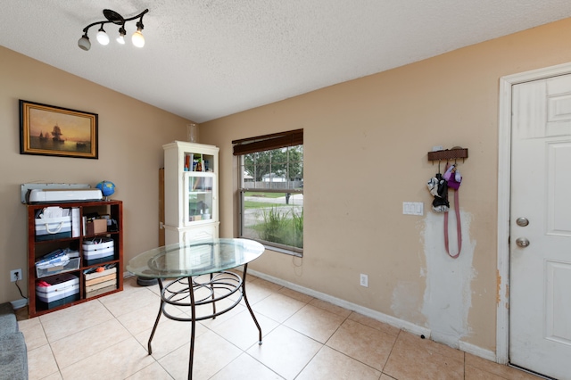 dining area featuring light tile patterned floors, a textured ceiling, and vaulted ceiling