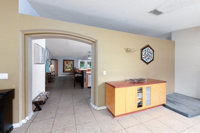 corridor featuring light tile patterned floors and a textured ceiling