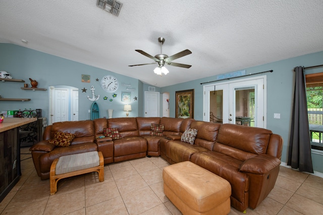 living room with light tile patterned floors, a textured ceiling, and vaulted ceiling