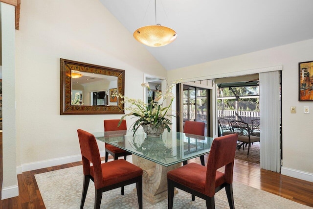 dining space featuring hardwood / wood-style floors and lofted ceiling