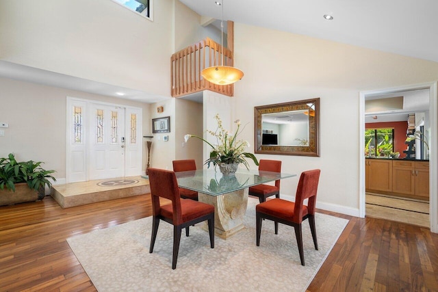 dining space featuring dark hardwood / wood-style flooring and high vaulted ceiling