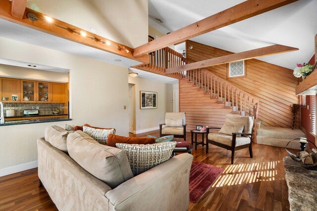 living room featuring beamed ceiling, high vaulted ceiling, and dark wood-type flooring