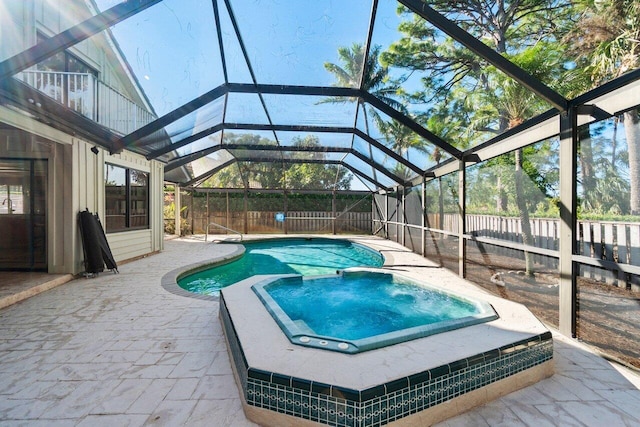 view of pool with a lanai, a patio area, and an in ground hot tub