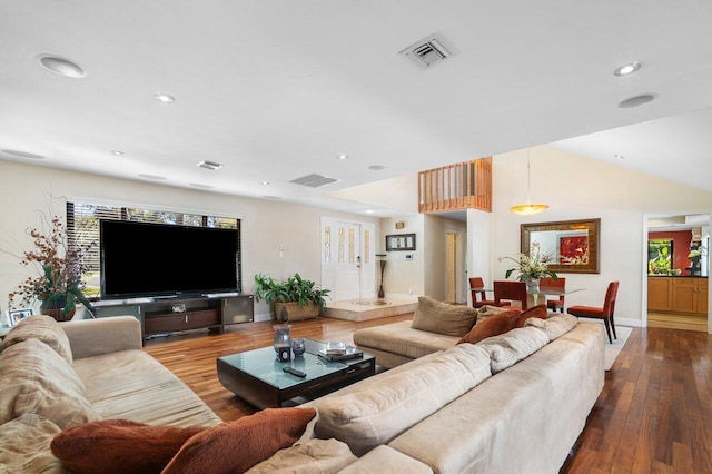 living room featuring plenty of natural light, wood-type flooring, and vaulted ceiling