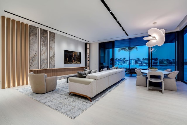 living room featuring wood-type flooring, expansive windows, and ceiling fan