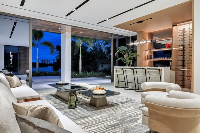 living room featuring bar area and a wall of windows