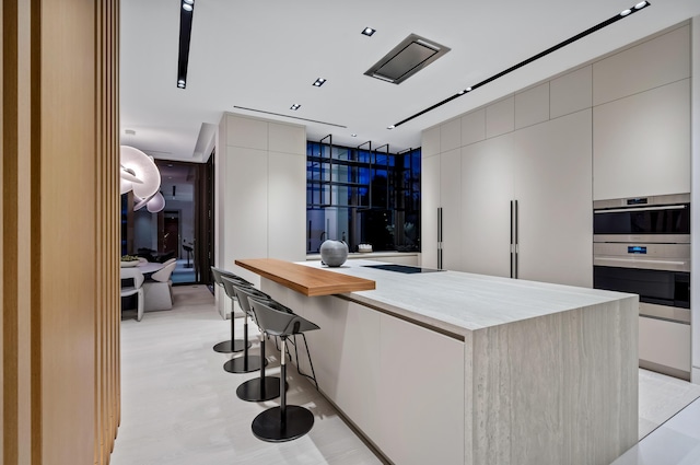 kitchen featuring a kitchen bar, double oven, and a large island