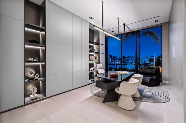 dining area featuring hardwood / wood-style floors, built in shelves, floor to ceiling windows, and an inviting chandelier