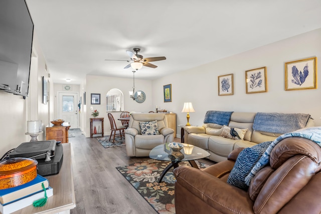 living room featuring light hardwood / wood-style floors and ceiling fan with notable chandelier