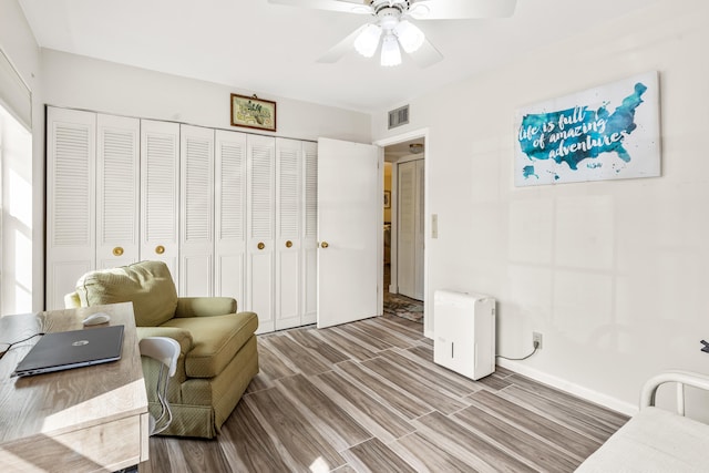 living area featuring hardwood / wood-style flooring and ceiling fan