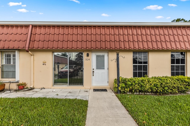 doorway to property with a lawn