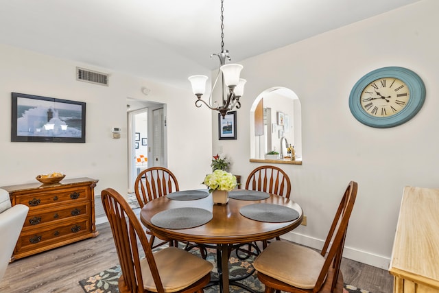 dining space with light hardwood / wood-style flooring and an inviting chandelier