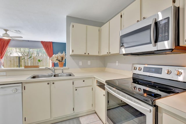 kitchen with stainless steel appliances, sink, ceiling fan, and light tile patterned floors