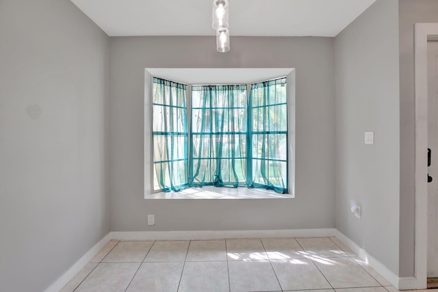 tiled spare room featuring plenty of natural light