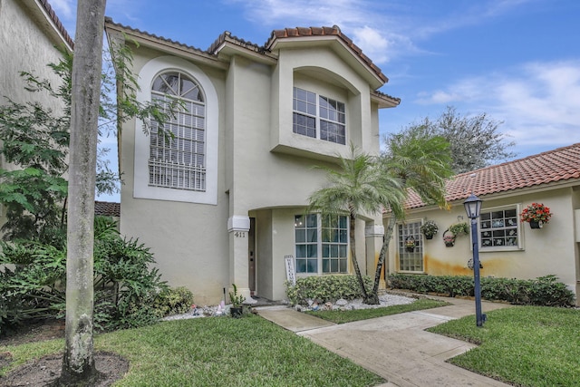 mediterranean / spanish house with a front lawn