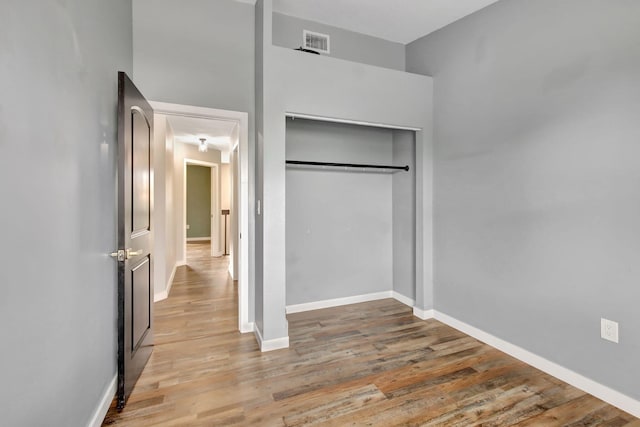 unfurnished bedroom featuring a closet and light wood-type flooring