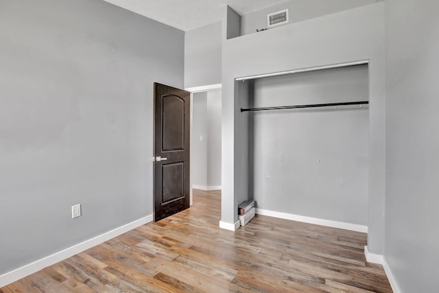 unfurnished bedroom featuring hardwood / wood-style flooring and a closet