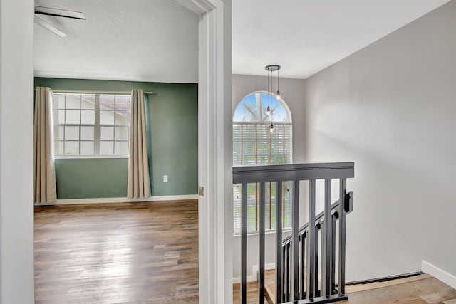 staircase featuring wood-type flooring and a chandelier