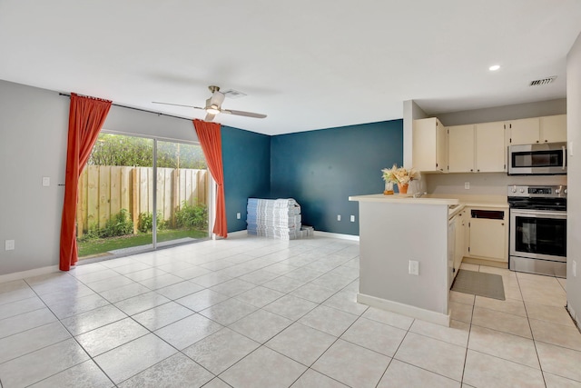 kitchen featuring stainless steel appliances, light tile patterned flooring, kitchen peninsula, ceiling fan, and cream cabinetry