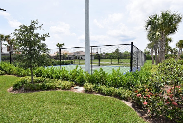 view of tennis court featuring a yard