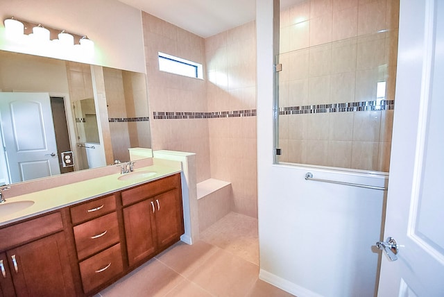 bathroom featuring tile patterned flooring, vanity, and tiled shower